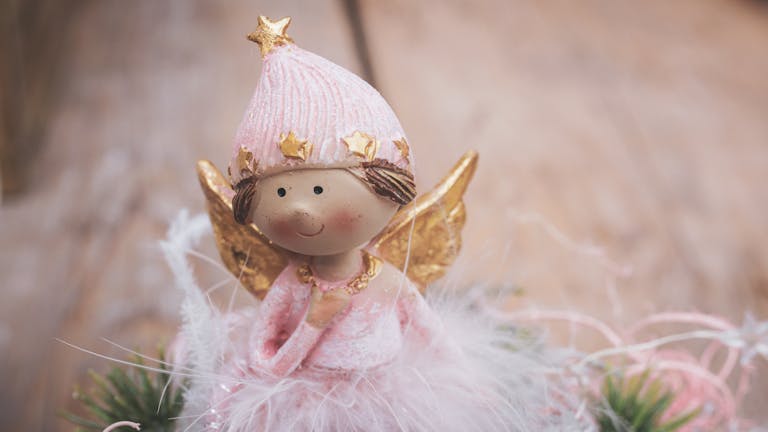 A cute Christmas angel figurine in pink and gold, perfect for festive decorations.
